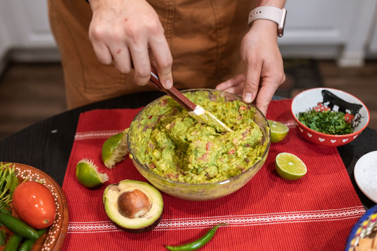 Preparation du guacamole traditionnel avec avocat, tomate et citron vert